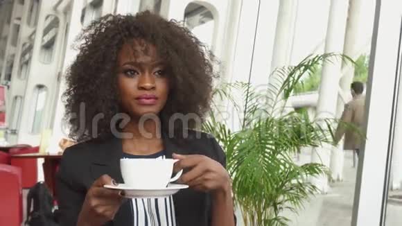 漂亮的非裔美国商务小姐在机场等待航班时喝咖啡视频的预览图