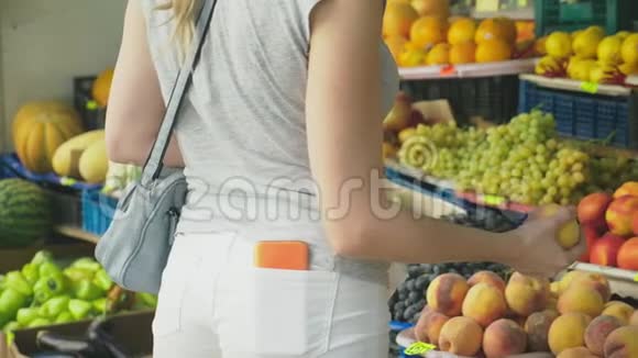 一个女人正在市场上选择蔬菜4k慢镜头视频的预览图