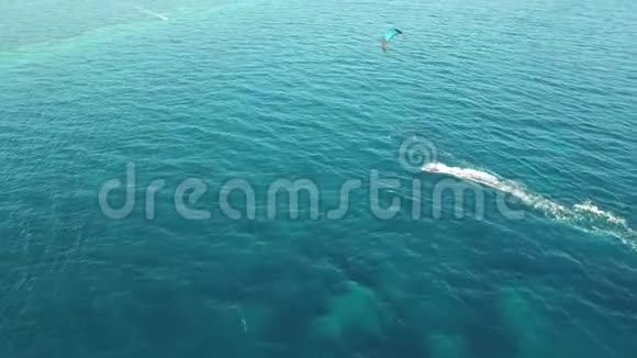 人们在风和日丽的夏日在清澈的蓝色绿松石海水中风筝在令人惊叹的4k无人驾驶飞机空中全景海景中视频的预览图