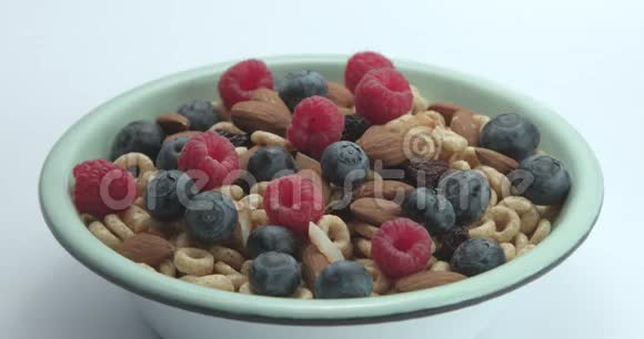 牛奶倒在碗里上面有玉米片上面有浆果和坚果视频的预览图
