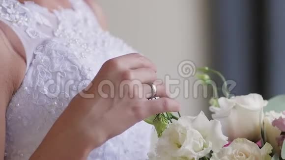 新娘手里拿着一束婚礼花束手指着花嗅着花束视频的预览图