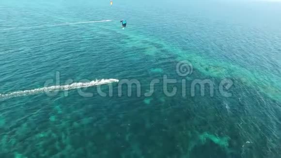 人们在晴朗的蓝色绿松石海水中在令人惊叹的4k无人驾驶飞机空中海景全景中在多风的夏日赤鸢视频的预览图