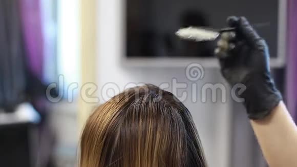 理发师将染发剂涂在头发特写上视频的预览图