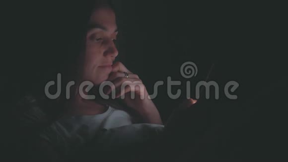 晚上在床上用手机的年轻女子视频的预览图