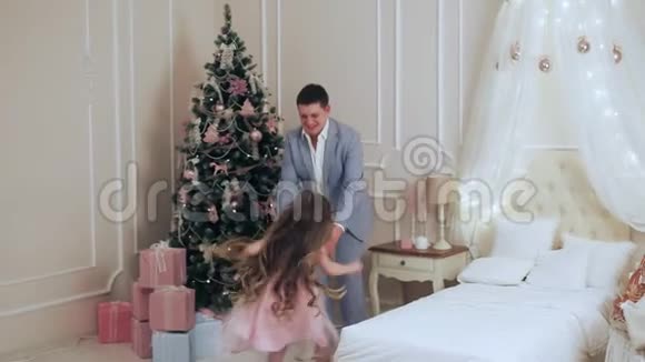 小孩在圣诞树旁拥抱他的父亲视频的预览图