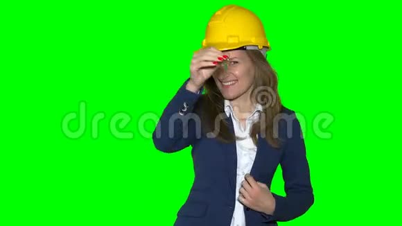 戴着黄色头盔手里拿着新房子钥匙的快乐房地产经纪人女孩视频的预览图