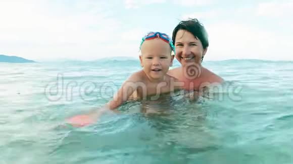 男孩和妈妈在海里玩球慢动作视频的预览图
