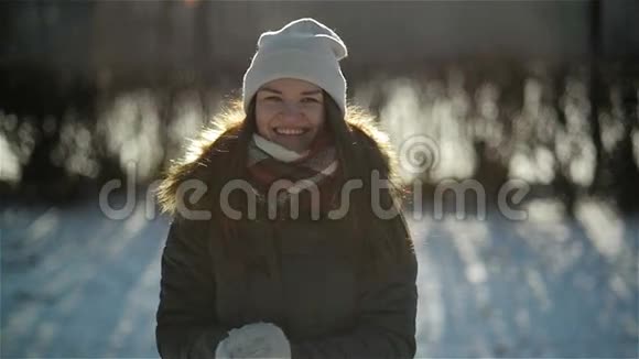 贪吃的女人在镜头前扔雪球在冬天有好玩的户外活动微笑女孩享受视频的预览图