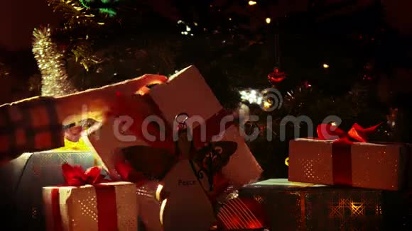 圣诞快乐孩子们手在圣诞树下拿起礼物4k视频的预览图