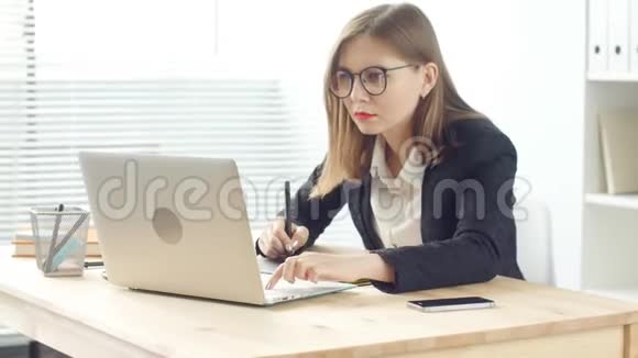 年轻女性平面设计师在现代办公室使用平板电脑工作视频的预览图