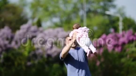 快乐的父亲抱着小女婴在公园里一起玩视频的预览图