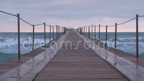 波浪在海上的木墩上飞溅日落时美丽的海景视频的预览图