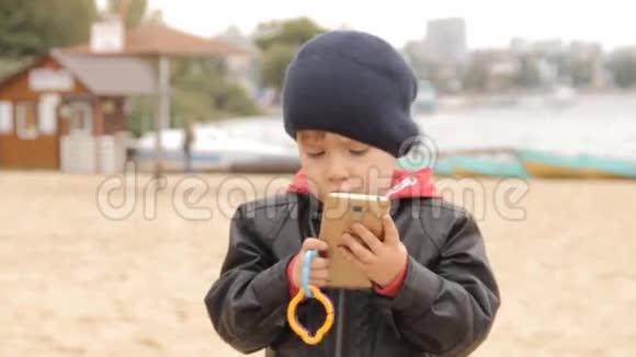 一个小男孩在智能手机上按下按钮接电话说话视频的预览图