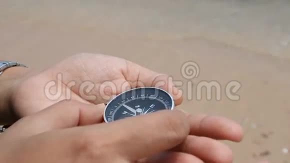 用指南针近距离拍摄女人在沙滩上与自然海岸视频的预览图