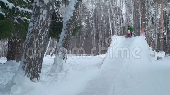 冬天从冰滑梯上骑马的小女孩视频的预览图