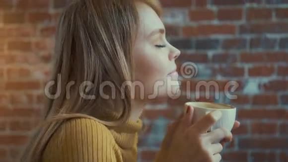 美丽的女孩正拿着白色的蒸汽咖啡在咖啡馆休息时微笑着视频的预览图