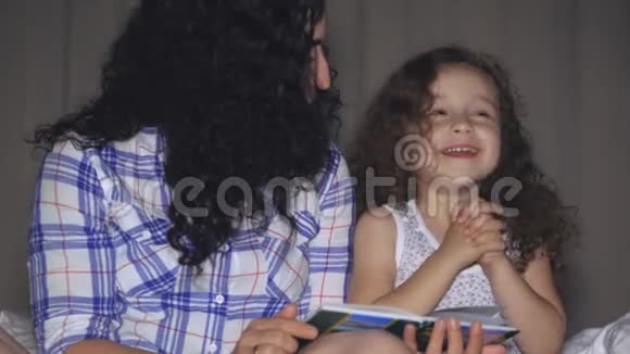 妈妈和一个漂亮的小女儿一起带着一个童话故事的情节读了一遍视频的预览图