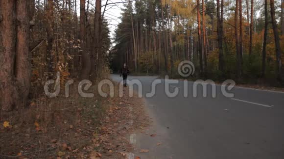 一个女孩走在路边一辆车经过在黑暗的森林里视频的预览图