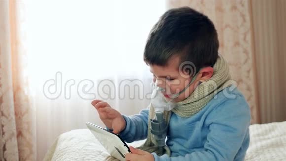 吸入用雾化器带氧气面罩的孩子在平板电脑上生病的孩子通过雾化器呼吸视频的预览图