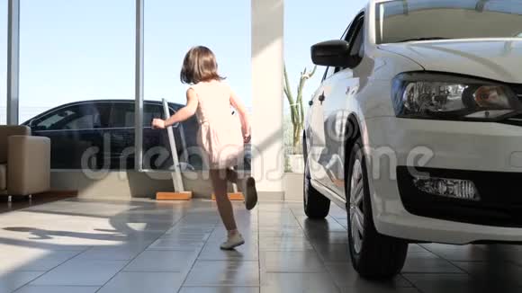 女孩子在汽车经销商汽车销售中心玩耍视频的预览图