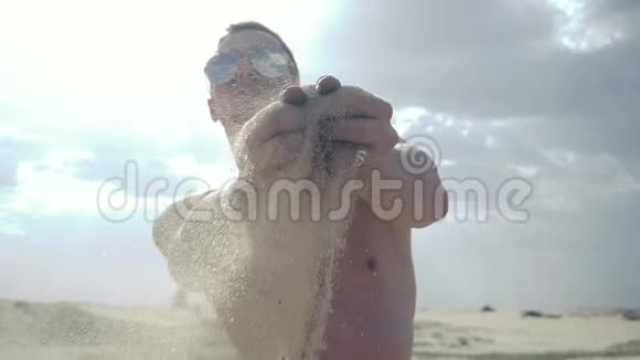 人把沙子从他的手指里倒出来视频的预览图