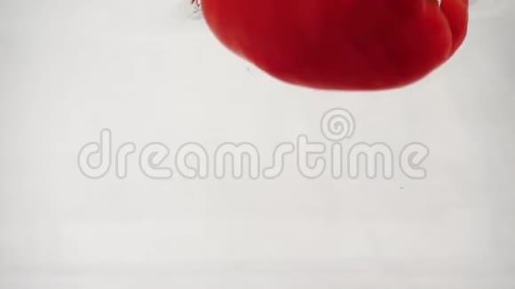 鲜红的甜椒掉入水中溅起水花和泡泡视频的预览图