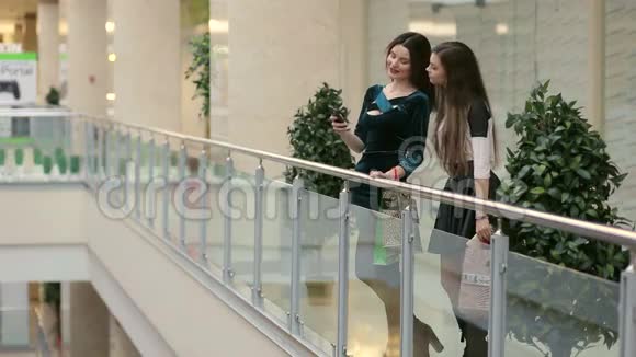 两个年轻的女朋友穿过购物中心视频的预览图