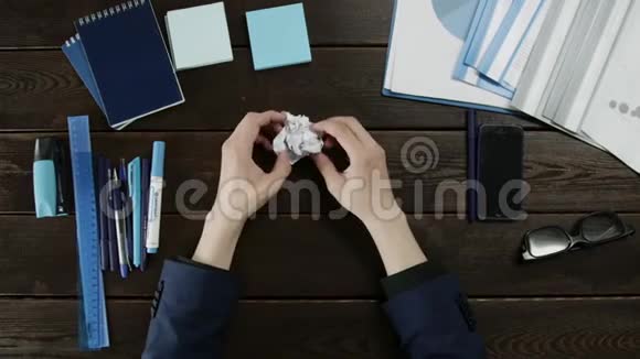 一个人打开一张皱巴巴的纸的俯视图视频的预览图