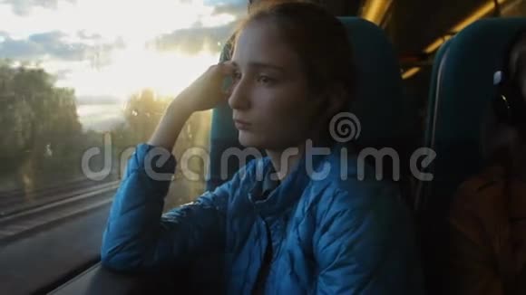 年轻的黑发时髦女孩看着火车上的窗户想着她的未来视频的预览图