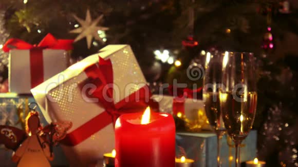 圣诞礼物和带有蜡烛的香槟酒杯4k视频的预览图