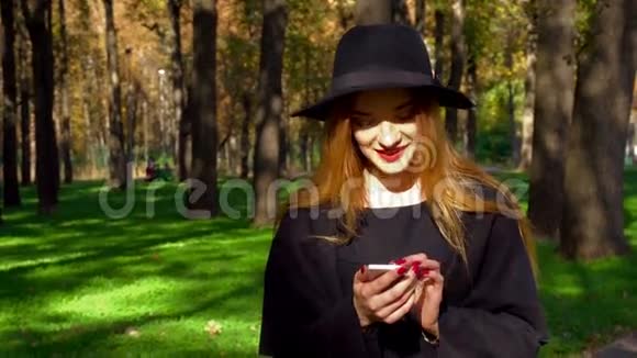 年轻时髦的女孩红唇使用智能手机视频的预览图