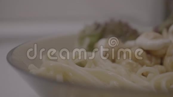 切片香肠和鸡面条鸡肉和酱汁的意大利面盘上的意大利面特写视频的预览图