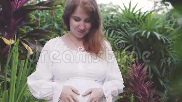 年轻快乐的孕妇在大自然中放松和享受生活视频的预览图