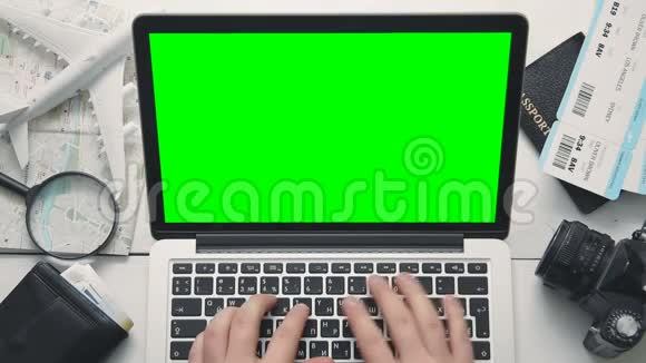 顶视图旅客白色木桌上使用带有绿色屏幕的笔记本电脑视频的预览图