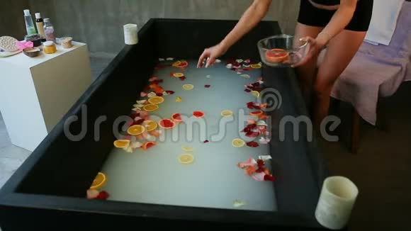 提供牛奶柑橘片和玫瑰花瓣的热美浴视频的预览图