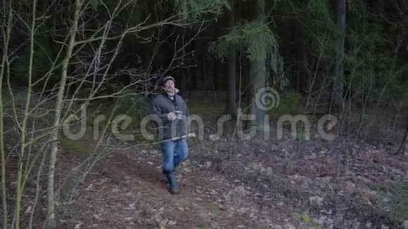 男人在森林里的长凳上吃三明治喝茶视频的预览图
