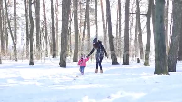 母亲和她的小女儿在雪地里散步视频的预览图