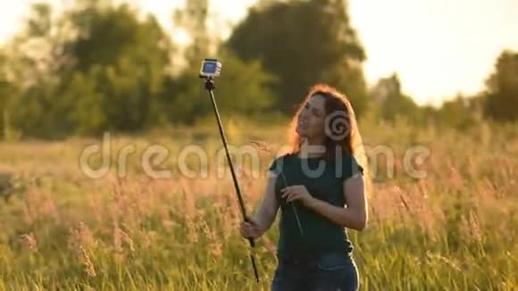 开朗的年轻女人在做自拍旅行温暖的音调日落时分视频的预览图