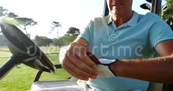 高尔夫球手戴着高尔夫球手套坐在高尔夫球车上视频的预览图