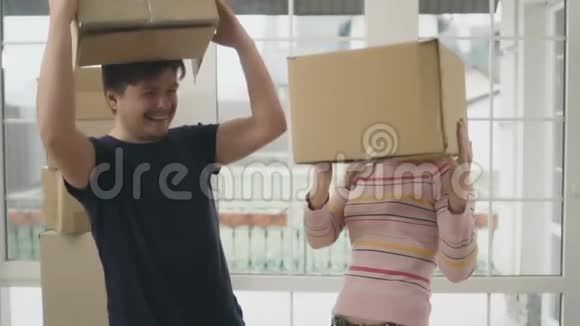 一对成年夫妇在新房子里拿着盒子玩得很开心视频的预览图