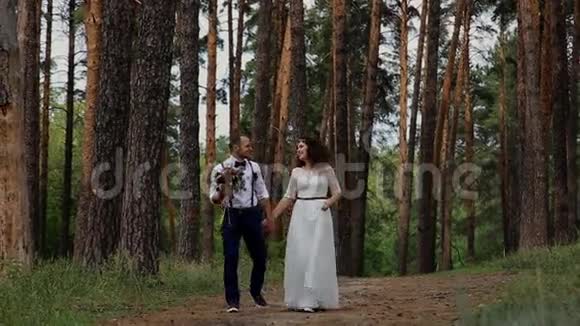 奢华的年轻女人和时髦的男人走在夏天的森林里相互交流面带微笑视频的预览图