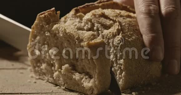 面包师把新鲜的白面包切在木板上视频的预览图