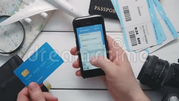 顶级游客用智能手机在白色的办公桌上在线支付机票视频的预览图