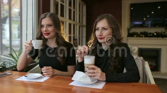 两个女孩在咖啡馆里喝咖啡的肖像视频的预览图
