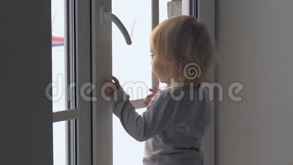 小女孩站在窗边看着外面视频的预览图