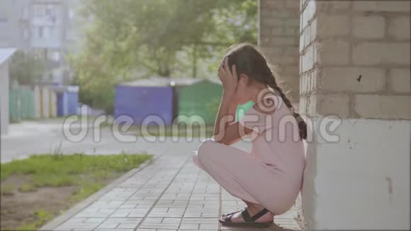 悲伤的小女孩坐在砖头旁边的墙上沮丧的慢动作视频少女生活方式令人心烦视频的预览图