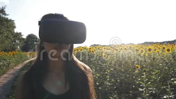 年轻女子使用头戴式户外显示器玩游戏使用VR头盔智能手机视频的预览图