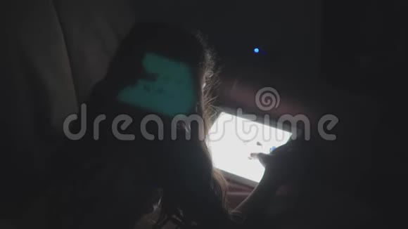 少女在网上买衣服小女孩晚上躺在沙发上在平板电脑上进行网上购物视频的预览图
