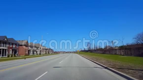 春日驾驶住宅道路司机的观点POV沿着美丽的阳光街道视频的预览图
