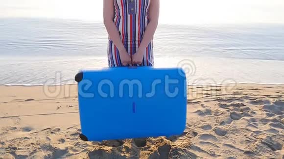 年轻快乐的女人带着一个大箱子在海滩上视频的预览图